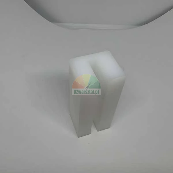 Biały plastikowy element dystansowy w kształcie litery U stojący na białym podłożu.