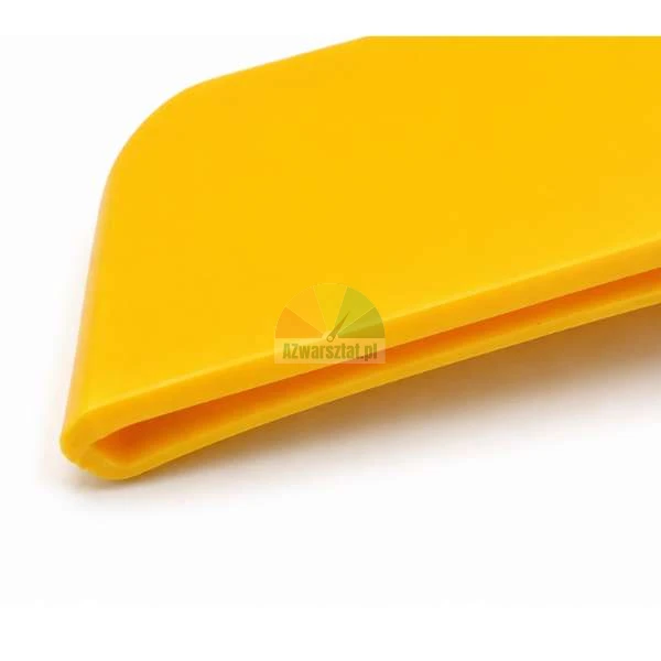 Zbliżenie na krawędź żółtej plastikowej rakli do folii i tapet na białym tle.